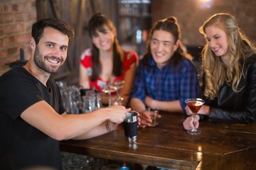 Portrait of handsome bartender making drinks for customers