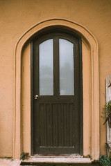 Black vintage door with brown frame and wall