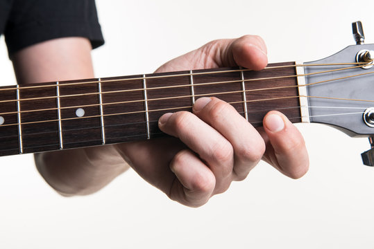 The guitarist's hand clamps the chord Dmon the guitar, on a white background. Horizontal frame