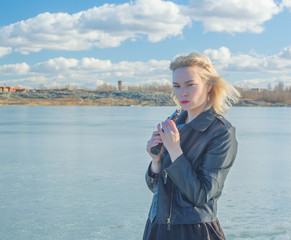 Fototapeta premium girl with a gun and a black jacket.
