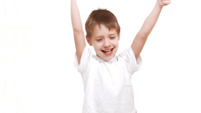 Cute elementary-school aged Caucasian boy smiling on white background and waving hands showing ok