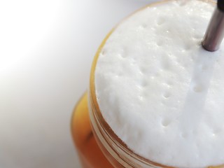 Thai popular beverage. Thai Ice Tea in mug with foam milk.