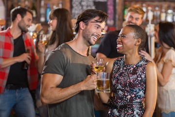 Happy young couple holding beer mugs