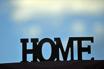 das Wort Home in grossen Buchstaben vor blauem Himmel