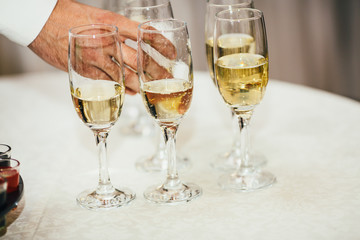 Elegant glasses with champagne standing in a white  table