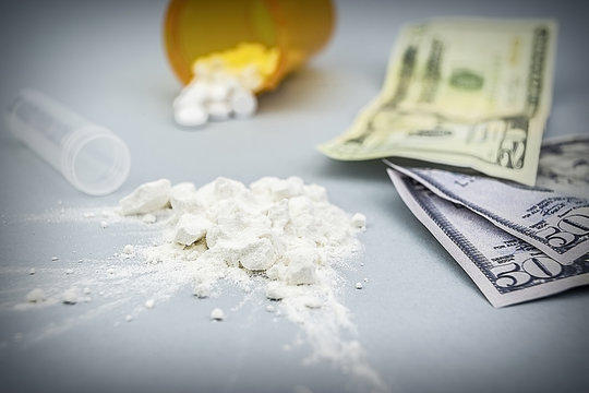 Cocaine drug powder pile along with several dollar tickets