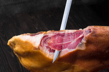 Jamon. Jamon serrano. Traditional Spanish ham on black close up.