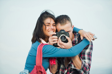 Happy girl hugging handsome man with camera