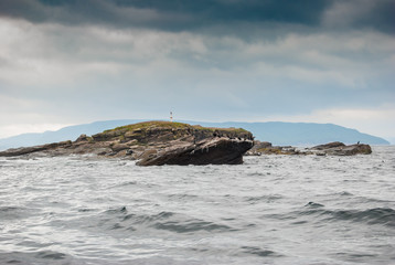 Rocky island off the coast of Cape Breton with roosting Cormorant birds and basking seals