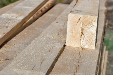 Pile of rectangular wooden beams in the construction site.