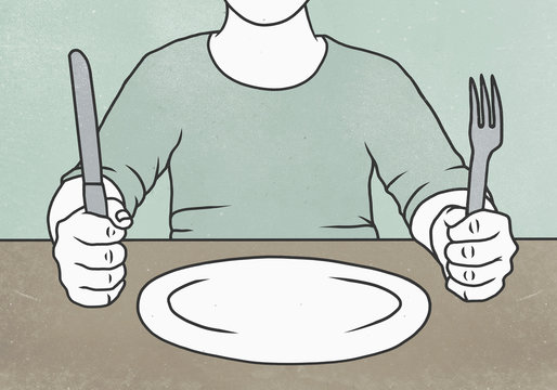 Midsection of man holding fork and knife at table