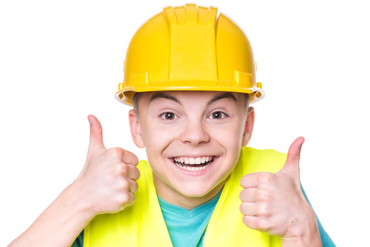 Emotional portrait of teen boy wearing safety yellow hard hat. Happy child making thumbs up gesture and looking at camera. Funny cute guy - engineer, entrepreneur, construction worker or architect.