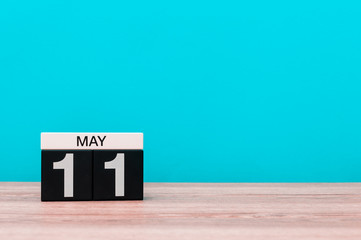May 11th. Day 11 of month, calendar on turquoise background. Spring time, empty space for text