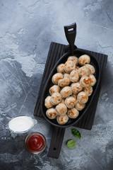 Roasted russian meat dumplings, above view over grey stone background, vertical shot