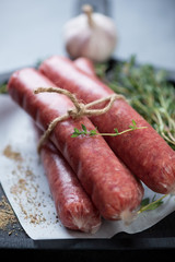 Closeup of fresh uncooked marbled beef sausages, vertical shot with shallow depth of field