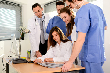 group of surgeons and medical professional staff discussing on patient radiography outside hospital operating room