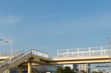 Pedestrian bridge over blue sky