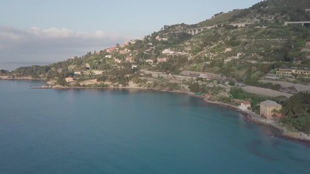 Flight over the mediterranean coastline on the border Italy France. Capo Mortola, Grimaldi (Ventimiglia), Italy, Europe. Aerial panoramic view 4K, UHD.
