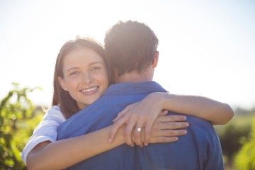 Happy woman hugging her boyfriend during sunny day