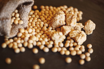 Close-up of heap healthy grains soybean on wooden background.