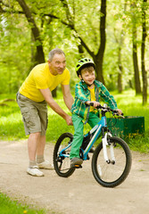 Fototapeta premium Father teaches his son to ride a bike