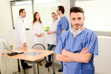 portrait of a young male surgeon residential student in hospital office wearing a operating room outfit