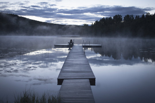 Pier on calm lake in foggy weather, Järvsö, Hälsingland, Sweden