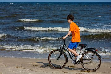 Fototapeta premium Teenage boy biking on beach