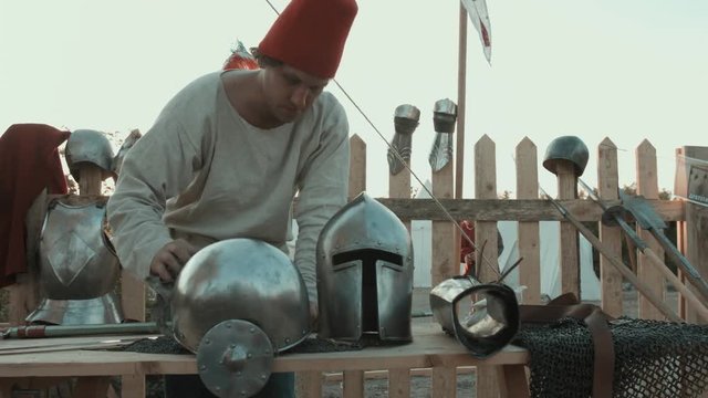 Medieval master rubbing iron armor, helmets and swords