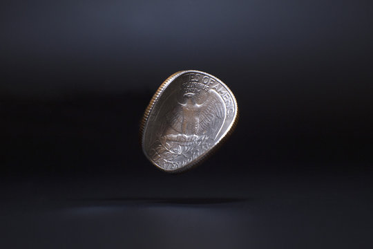 Close-up of damaged Washington quarter dollar levitating against black background