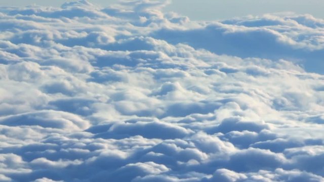 Flying through clouds. Beautiful blue clouds from plane view