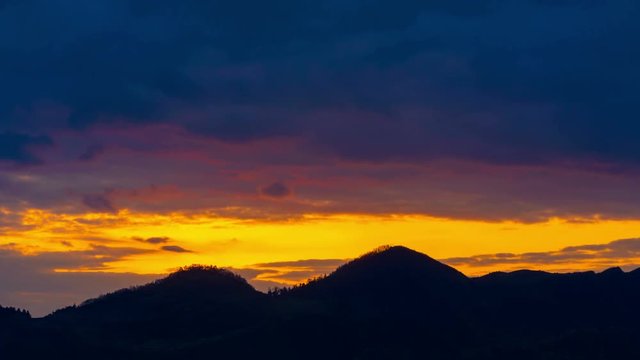 4K Time Lapse:Mountain's silhouette with golden sky.