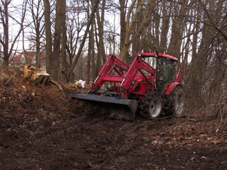 Cleaning a garbage dump by a tractor