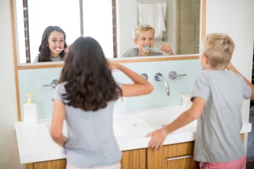 Fototapeta premium Siblings brushing their teeth in bathroom