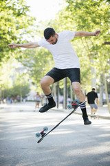 Fototapeta premium Young man longboarding outdoors. Male skateboarding on a sunny day.