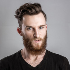 Obraz premium Very angry young man isolated on gray background