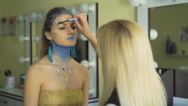 Make-up artist making bodyart of peahen for carnival and halloween for girl 4K