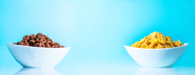 Yellow and chocolate flakes in white plates cup on a blue background close-up. Big large photo size. Vibrant bright color.