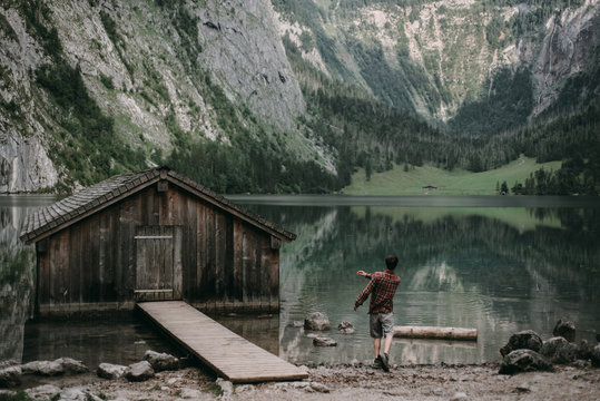 Man skipping stones in mountain lake