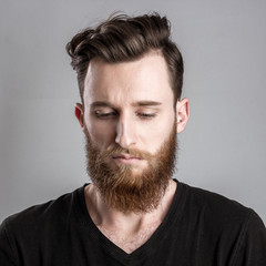 Fototapeta premium Sad and unhappy young man isolated on gray backround