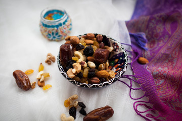 plate with nuts and dried fruits lying on a white table