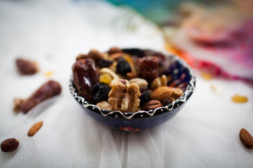 plate with nuts and dried fruits lying on a white table