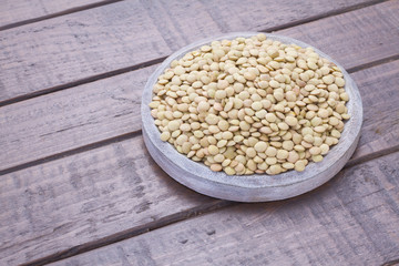Pile of lentils on wooden background (Lens culinaris)
