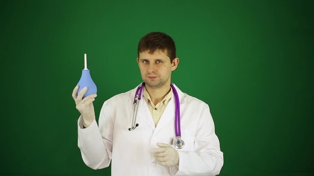Doctor with an enema in his hands. The doctor is holding an enema.
