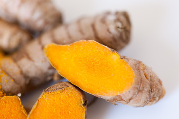 Turmeric roots macro with turmeric powder isolated on white background