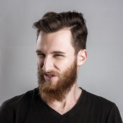 Obraz premium Treacherous and crafty young man isolated on gray background
