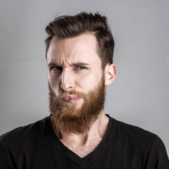 Fototapeta premium Unconfident and worried young man isolated on gray background