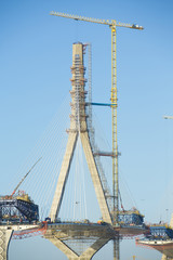 Fototapeta na wymiar Construction of big guyed bridge in Cádiz over the sea