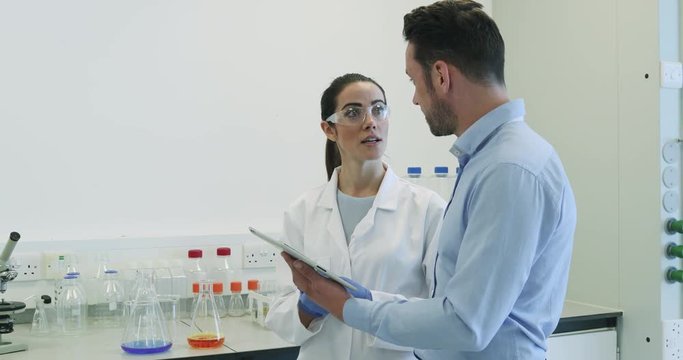 Female scientist discussing data with pharmaceutical sales rep