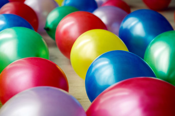 Inflatable multicolored balls lie on the white floor on holiday